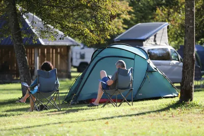 Kamp Soča - Camper sitzen vor einem Zelt auf dem Stellplatz