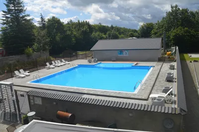 Kruså Camping og Hytter - Pool mit Liegestühlen und Sonnenschirmen auf dem Campingplatz