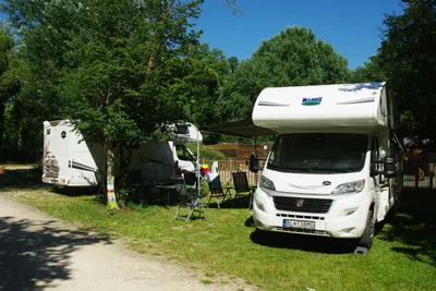 Camping L' Art de Vivre - Wohnmobile auf Stellplatz mit Sitzgelegenheiten