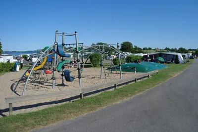Lærkelunden Camping - Spielplatz vom Campingplatz mit Rutsche und Trampolin mit Blick auf das Meer