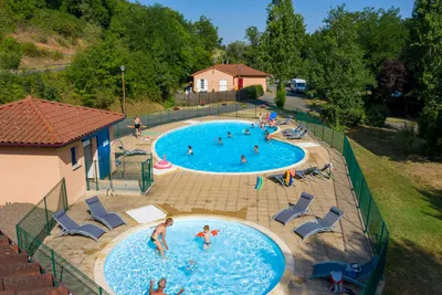 Camping La Bageasse - Pool mit Liegestühlen und Sonnenschirmen auf dem Campingplatz