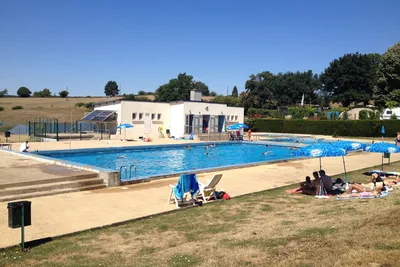 Camping La Bedure  -  Camper am Pool vom Campingplatz mit Sonnenschirmen und Liegestühlen