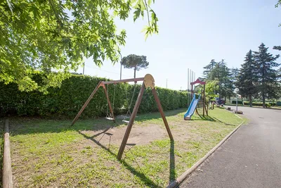 Camping La Perla del Lago - Kinderspielplatz mit Schaukeln und Kletterburg mit Rutschen