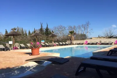 Camping La Roquette - Poolbereich mit Liegestühlen und Sonnenschirmen