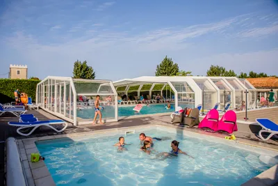 Camping La Tour des Prises  -   Pool vom Campingplatz mit Kinderbecken und Liegestühlen in der Sonne