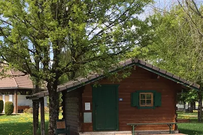 Camping Le Bivouac -  Chalet mit Veranda im Grünen auf dem Campingplatz