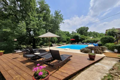 Le Mas du Midi - Liegestühle und Sonnenschirme am Pool des Campingplatzes