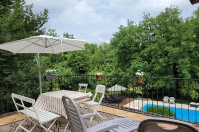 Le Mas du Midi - Terrasse eines Ferienapartments mit Blick auf den Pool auf dem Campingplatz