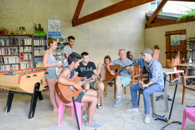 Le Vieux Colombier - Gitarrenstunde im Gemeinschaftsraum mit Büchern, Tischfußball und Spielen