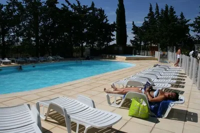Camping Les Clairettes  -  Camper auf einem Liegestuhl am  Pool vom Campingplatz