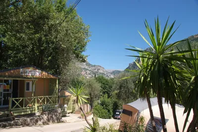 Camping Les Gorges du Loup  -  Hauptgebäude und Stellplatz vom Campingplatz mit Blick auf die Berge im Parc naturel régional des Préalpes d'Azur
