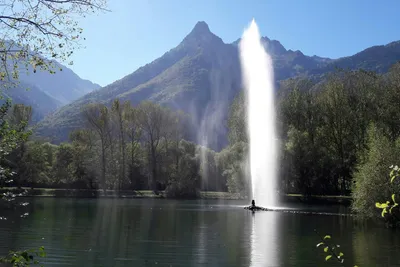 camping les lacs de maurienne  - Blick vom Campingplatz auf eine Fontäne im See und Berge