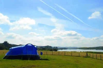 Loch Ken Holiday Park  -  Zeltstellplatz auf grüner Wiese mit Blick auf den Fluss