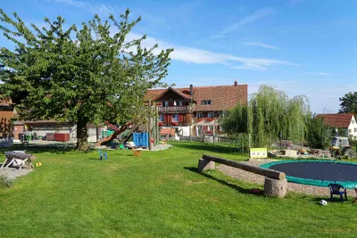 Camping Manser - Bauernhaus und Kinderspielplatz auf dem Campingplatz