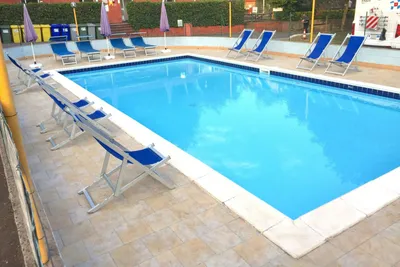 Camping Miraflores - Swimmingpool auf dem Campingplatz mit Liegestühlen und Sonnenschirmen