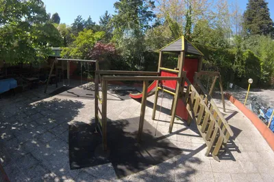 Camping Miraflores - Kinderspielplatz mit Kletterburg und Schaukeln auf dem Campingplatz