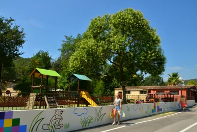 Camping Parc Saint James Le Sourire  - Camper auf einem Gehweg entlang von einem Spielplatz
