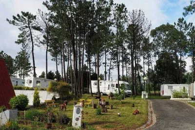 Parque de Campismo De Luso - Wohnmobile auf dem Stellplatz im Grünen mit kleinem Sitzgarten im Vordergrund