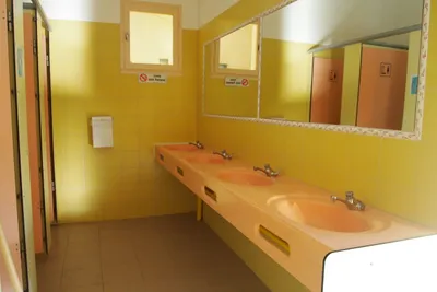 Camping Rose de Provence - Innenansicht des Sanitärbereichs mit Waschbecken und Duschkabinen