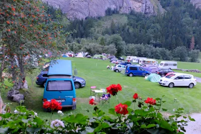 Camping Rütti  -  Wohnwagen- und Zeltstellplatz vom Campingplatz auf einer Wiese umgeben von Bäumen und Bergen