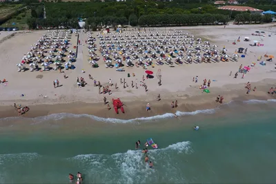 Camping Spinnaker - Strand vom Campingplatz mit Liegestühlen und Sonnenschirmen