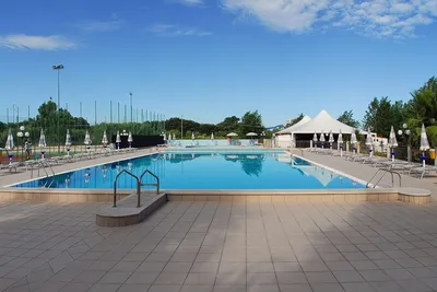 Camping Stella del Sud - Swimmingpool mit Liegestühlen und Sonnenschirmen am Rand