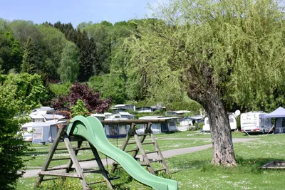 Strandcamping Obertrum - Kinderrutsche mit Stellplätzen im Hintergrund