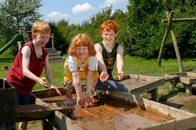 Camping Südstrand - Kinder beim Wasserspiel im Grünen auf dem Campingplatz