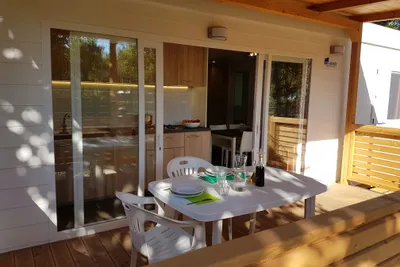 Camping Taimi  - Esstisch auf der Veranda vom Mobilheim mit Blick in den Kochbereich